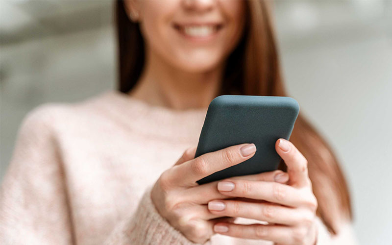 Mãos preenchendo o cadastro na tela do celular